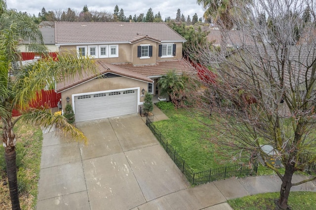 view of front of property featuring fence, a tiled roof, concrete driveway, a front lawn, and stucco siding