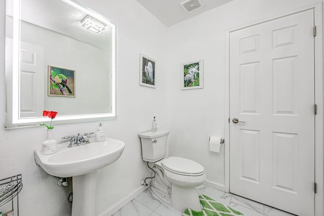 bathroom featuring marble finish floor, toilet, baseboards, and visible vents