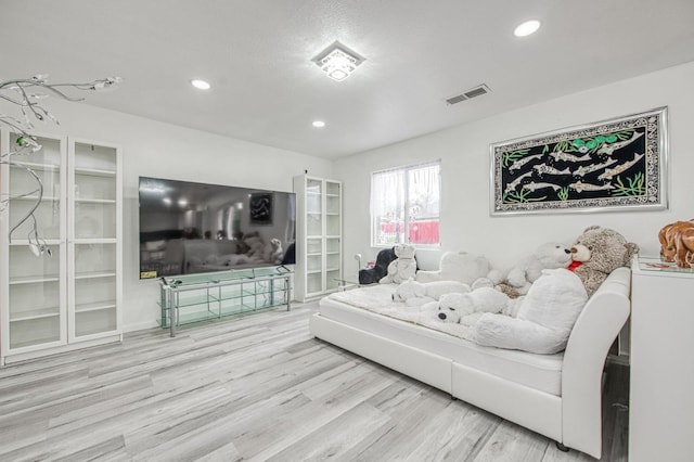 living area with visible vents, wood finished floors, and recessed lighting