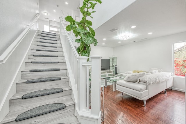 staircase with visible vents, wood finished floors, and recessed lighting