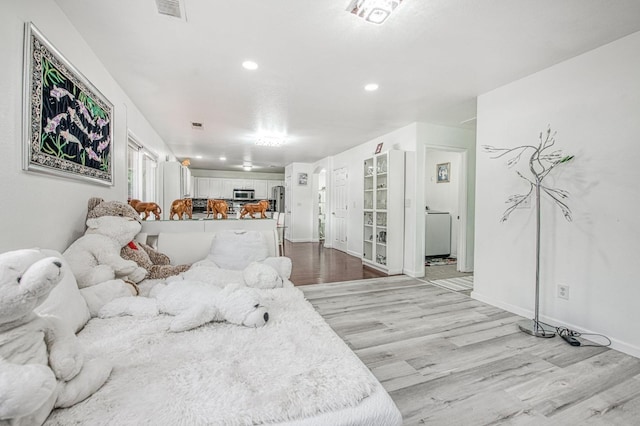 living area with light wood finished floors, baseboards, visible vents, and recessed lighting
