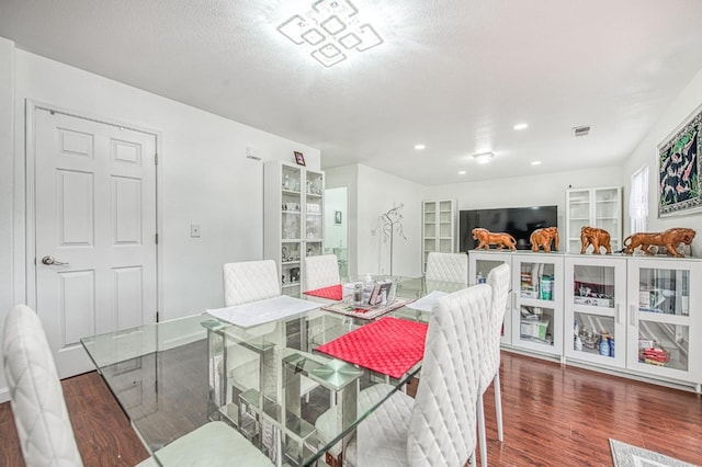 dining space featuring visible vents, a textured ceiling, wood finished floors, and recessed lighting