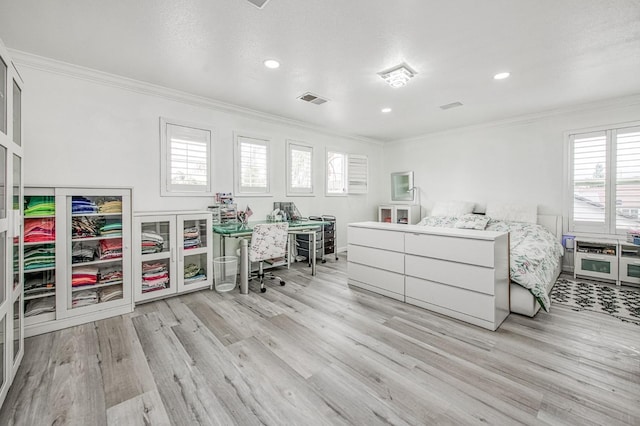 bedroom featuring light wood-style flooring, crown molding, and visible vents
