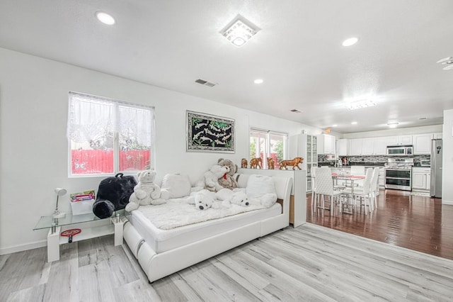 bedroom featuring recessed lighting, baseboards, visible vents, freestanding refrigerator, and light wood-style flooring