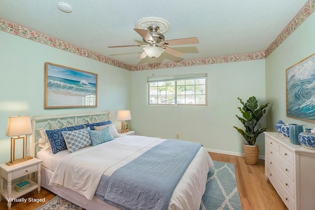 411 W Vartikian Ave W, Fresno, CA 93704 - bedroom featuring a textured ceiling, light wood-type flooring, a ceiling fan, and baseboards