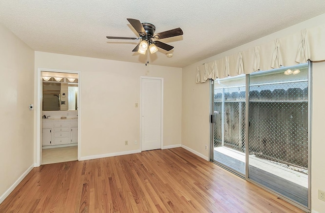 unfurnished bedroom featuring baseboards, a textured ceiling, and light wood finished floors