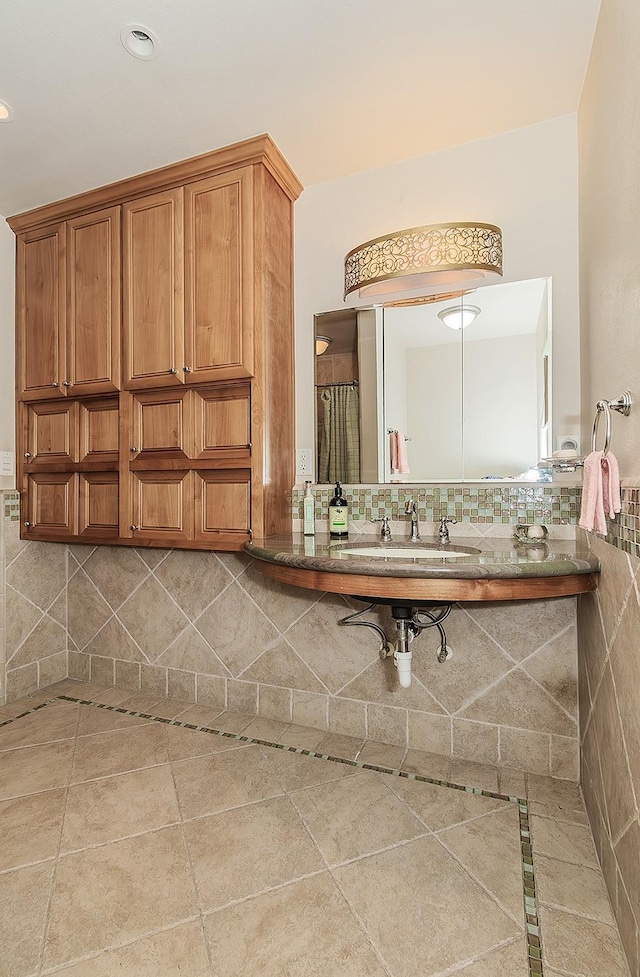 bathroom with tile patterned flooring, a sink, backsplash, and recessed lighting