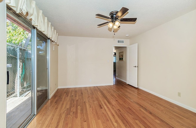 spare room featuring light wood-style flooring, visible vents, a ceiling fan, and baseboards