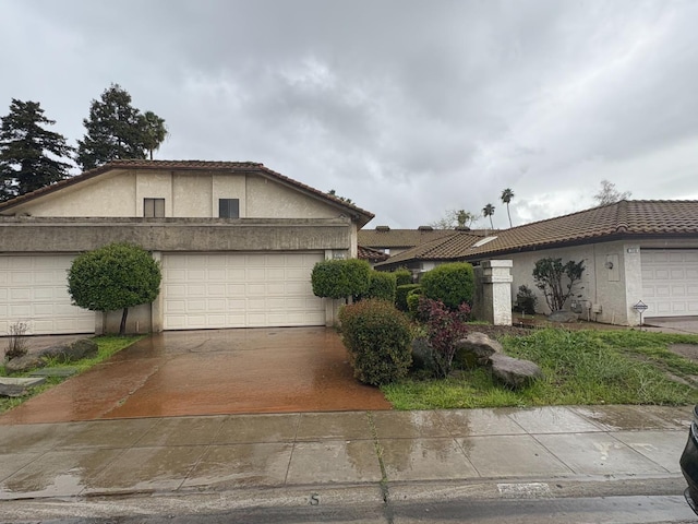 2512 Driftwood Dr, Madera, CA 93637 - view of front of property featuring a tile roof, concrete driveway, stucco siding, and an attached garage