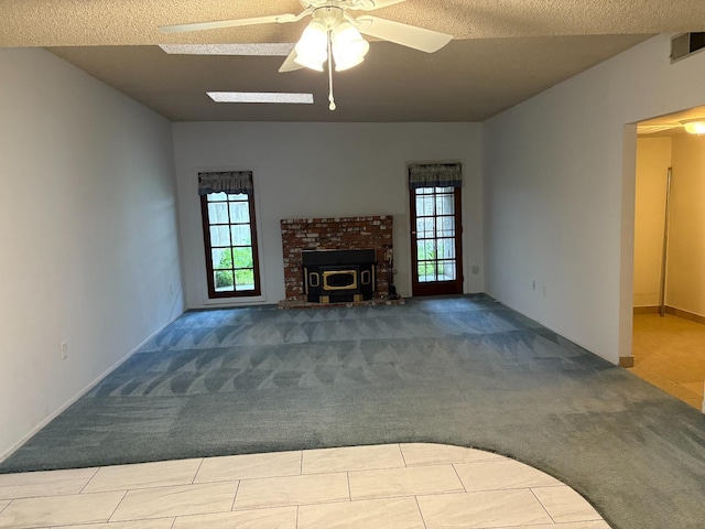2512 Driftwood Dr, Madera, CA 93637 - unfurnished living room with a ceiling fan, a fireplace, a textured ceiling, visible vents, and carpet