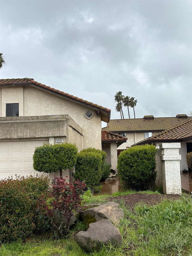 2512 Driftwood Dr, Madera, CA 93637 - view of front of home featuring stucco siding, an attached garage, and a tiled roof