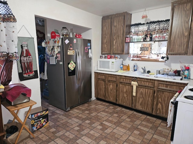 2690 S Cedar, Fresno, CA 93725 - kitchen with freestanding refrigerator, white microwave, range with gas stovetop, light countertops, and a sink