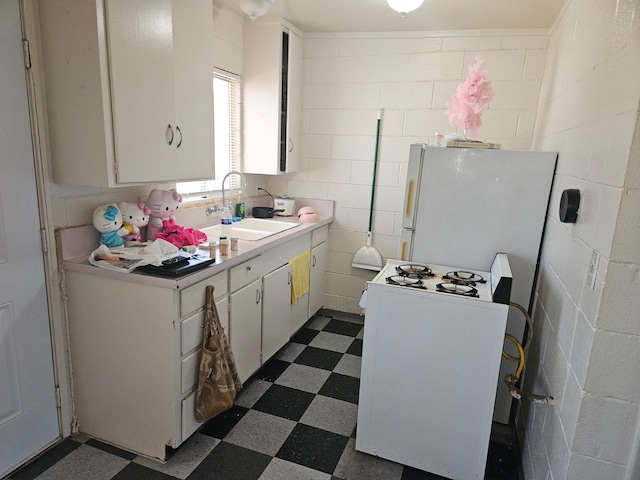 2690 S Cedar, Fresno, CA 93725 - kitchen with dark flooring, a sink, white appliances, light countertops, and concrete block wall