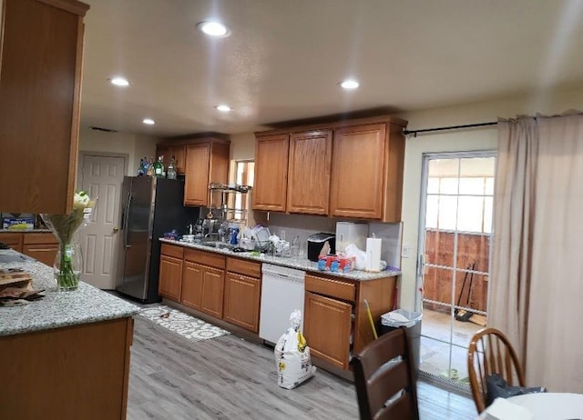 2744 N Locan Ave, Fresno, CA 93619 - kitchen with dishwasher, brown cabinetry, recessed lighting, and freestanding refrigerator
