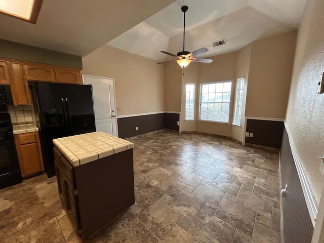 18149 Varden Dr, Madera, CA 93638 - kitchen with visible vents, a ceiling fan, tile countertops, black fridge, and stove