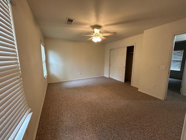 18149 Varden Dr, Madera, CA 93638 - unfurnished bedroom with baseboards, dark carpet, ceiling fan, visible vents, and a closet