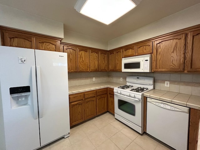 18149 Varden Dr, Madera, CA 93638 - kitchen with tile countertops, brown cabinets, and white appliances