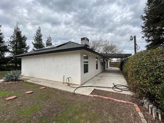 18149 Varden Dr, Madera, CA 93638 - view of side of home featuring stucco siding, fence, a patio, and solar panels