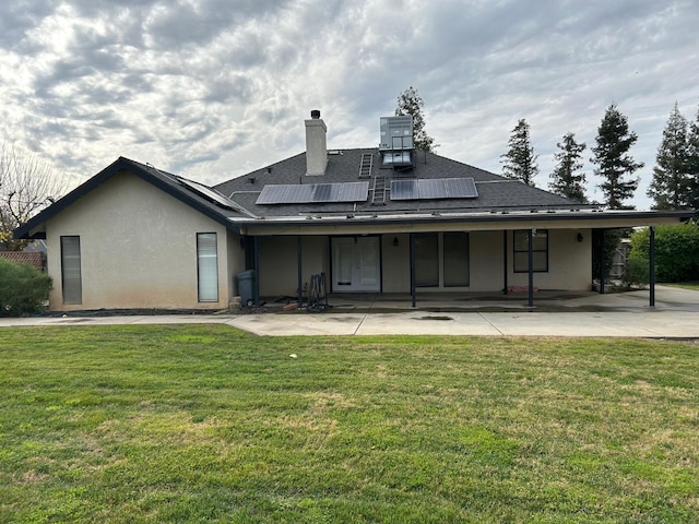 18149 Varden Dr, Madera, CA 93638 - rear view of house featuring a lawn, stucco siding, a patio area, and roof mounted solar panels