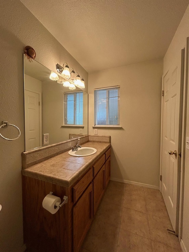 18149 Varden Dr, Madera, CA 93638 - bathroom with a textured ceiling, baseboards, tile patterned floors, vanity, and a textured wall