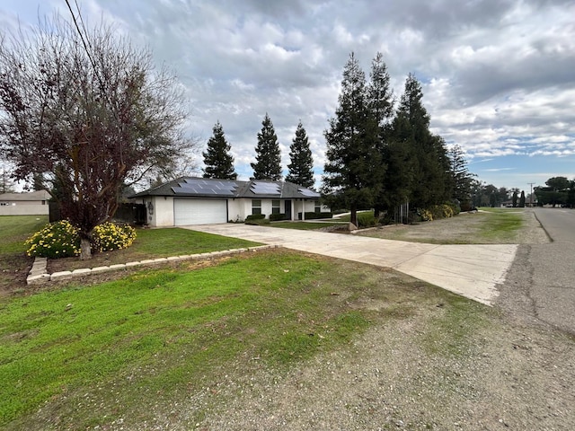 18149 Varden Dr, Madera, CA 93638 - single story home with concrete driveway, stucco siding, a front yard, solar panels, and a garage
