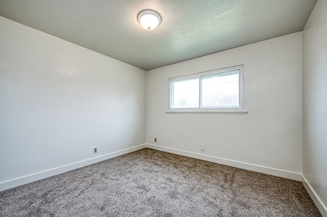 carpeted empty room featuring baseboards and a textured ceiling