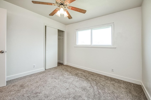 unfurnished bedroom with baseboards, a ceiling fan, carpet, and a closet