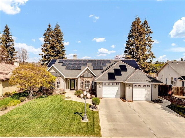 355 Old Line Ave, Exeter, CA 93221 - view of front of house featuring roof mounted solar panels, fence, driveway, roof with shingles, and a front yard