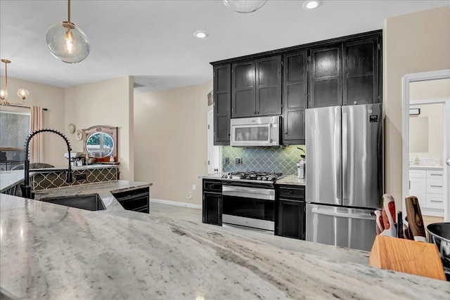 355 Old Line Ave, Exeter, CA 93221 - kitchen with decorative backsplash, appliances with stainless steel finishes, dark cabinetry, and a sink
