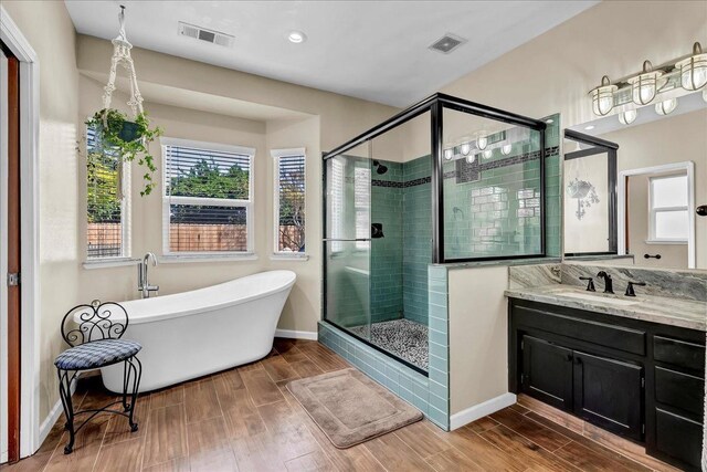 355 Old Line Ave, Exeter, CA 93221 - full bath with a shower stall, wood finished floors, visible vents, baseboards, and a soaking tub