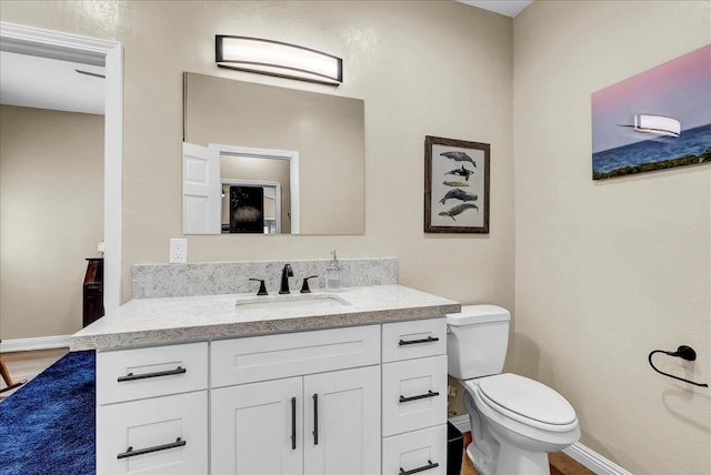 355 Old Line Ave, Exeter, CA 93221 - bathroom with baseboards, toilet, vanity, and wood finished floors