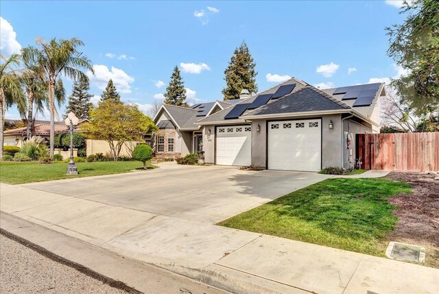 355 Old Line Ave, Exeter, CA 93221 - view of front facade with a front lawn, driveway, fence, an attached garage, and roof mounted solar panels