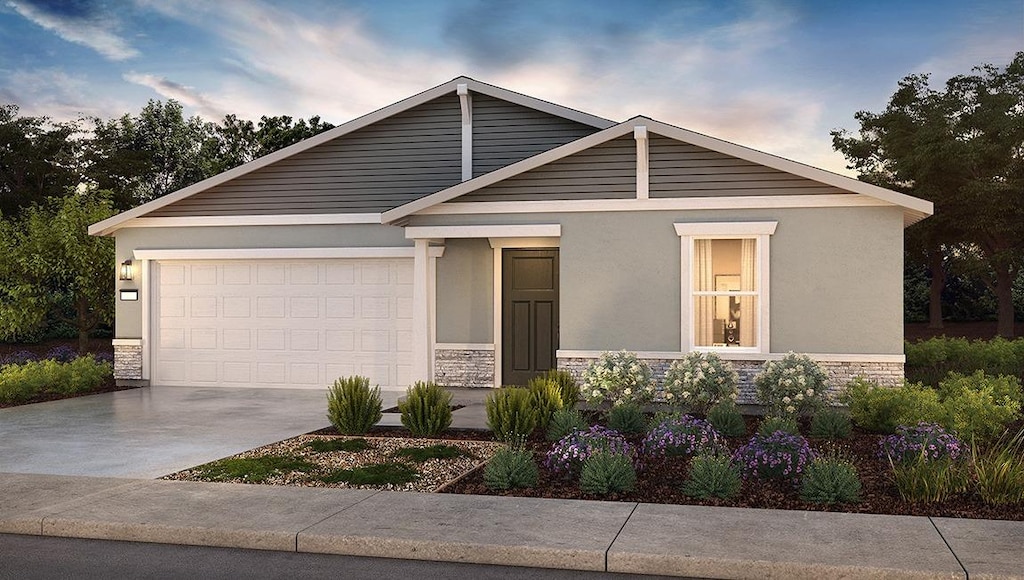 view of front of home with stone siding, driveway, a garage, and stucco siding
