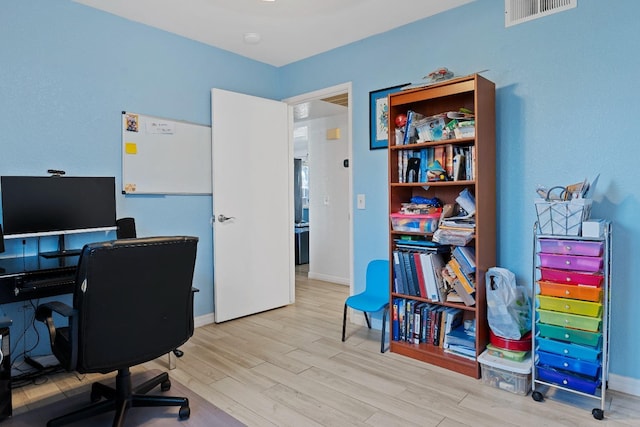 office featuring wood finished floors, baseboards, and visible vents