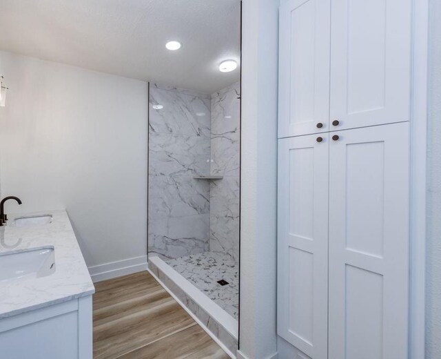 655 E Normal Ave, Fresno, CA 93704 - full bathroom featuring baseboards, a marble finish shower, wood finished floors, and double vanity
