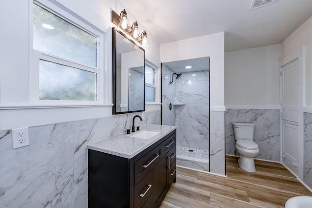 655 E Normal Ave, Fresno, CA 93704 - full bathroom with tile walls, toilet, vanity, a marble finish shower, and a wainscoted wall