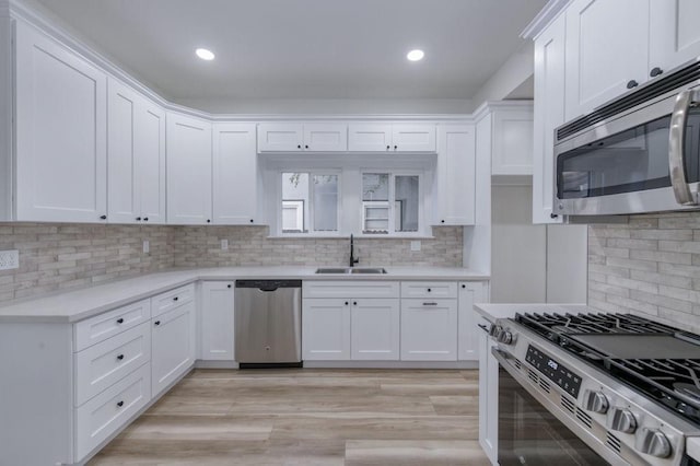 655 E Normal Ave, Fresno, CA 93704 - kitchen featuring stainless steel appliances, a sink, white cabinets, backsplash, and light countertops