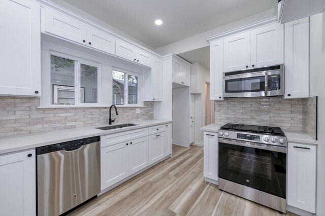 655 E Normal Ave, Fresno, CA 93704 - kitchen featuring appliances with stainless steel finishes, a sink, white cabinets, light countertops, and light wood finished floors