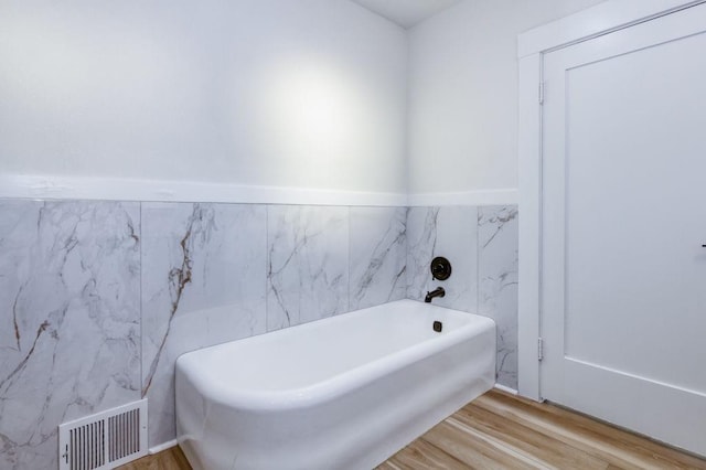 655 E Normal Ave, Fresno, CA 93704 - full bath featuring tile walls, wood finished floors, a garden tub, and wainscoting
