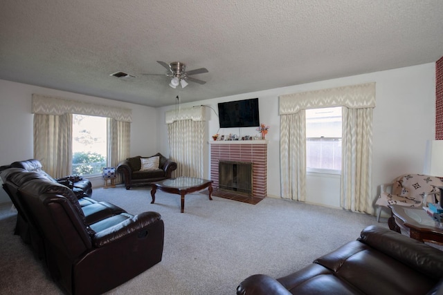 living room with a ceiling fan, visible vents, carpet, and a textured ceiling