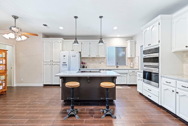 1110 Minarets Ave, Clovis, CA 93611 - kitchen featuring white refrigerator with ice dispenser, stainless steel double oven, white cabinets, dark wood-style flooring, and recessed lighting