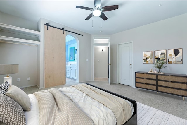 1110 Minarets Ave, Clovis, CA 93611 - bedroom featuring light colored carpet, arched walkways, a barn door, and baseboards
