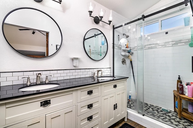 bathroom with a shower stall, double vanity, backsplash, and a sink
