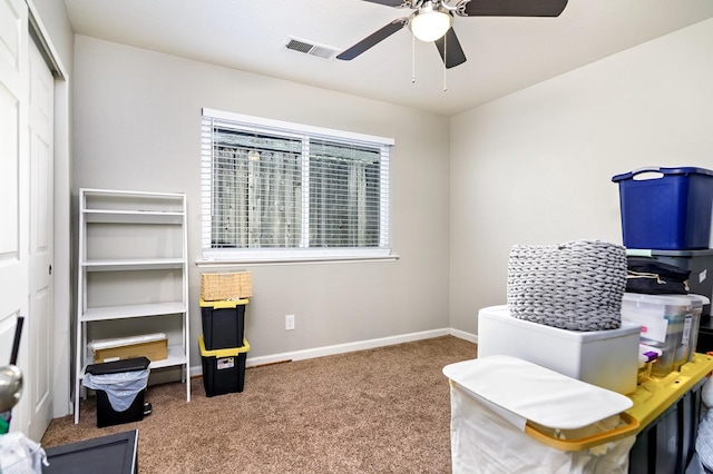 carpeted home office featuring baseboards, visible vents, and a ceiling fan