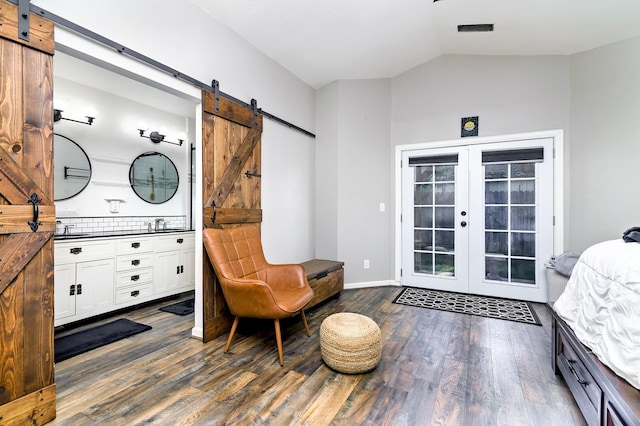 sitting room with vaulted ceiling, french doors, dark wood-style flooring, a barn door, and visible vents