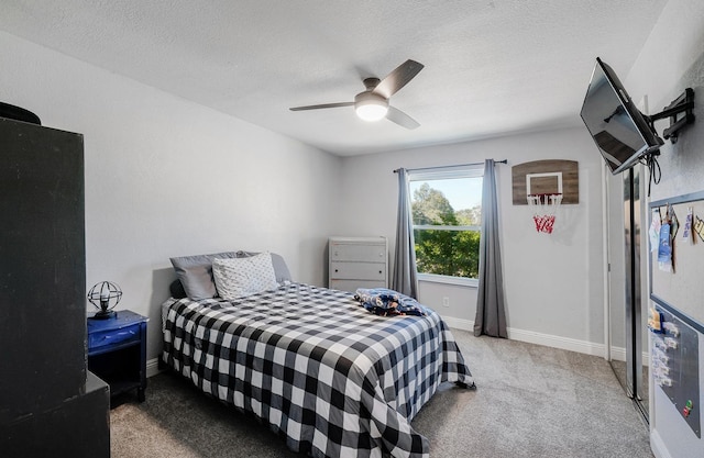 carpeted bedroom featuring baseboards, ceiling fan, and a textured ceiling