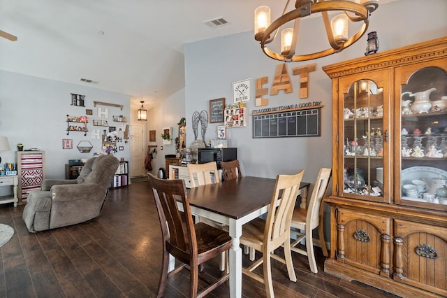 dining area featuring a chandelier, dark wood-style flooring, vaulted ceiling, and visible vents
