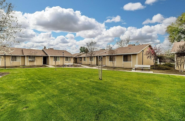 rear view of house with a yard, a residential view, and a patio area