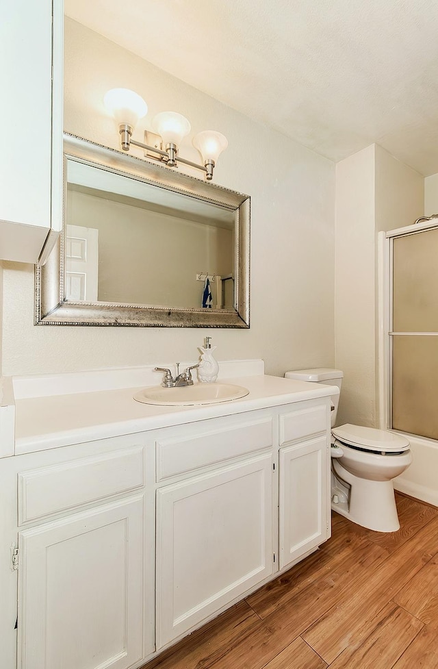 full bathroom featuring vanity, wood finished floors, and toilet