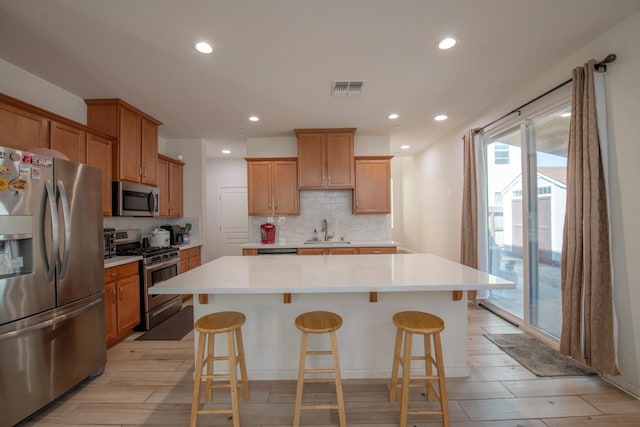 4865 E Alexander Ave, Fresno, CA 93725 - kitchen featuring stainless steel appliances, a kitchen island, healthy amount of natural light, tasteful backsplash, and recessed lighting